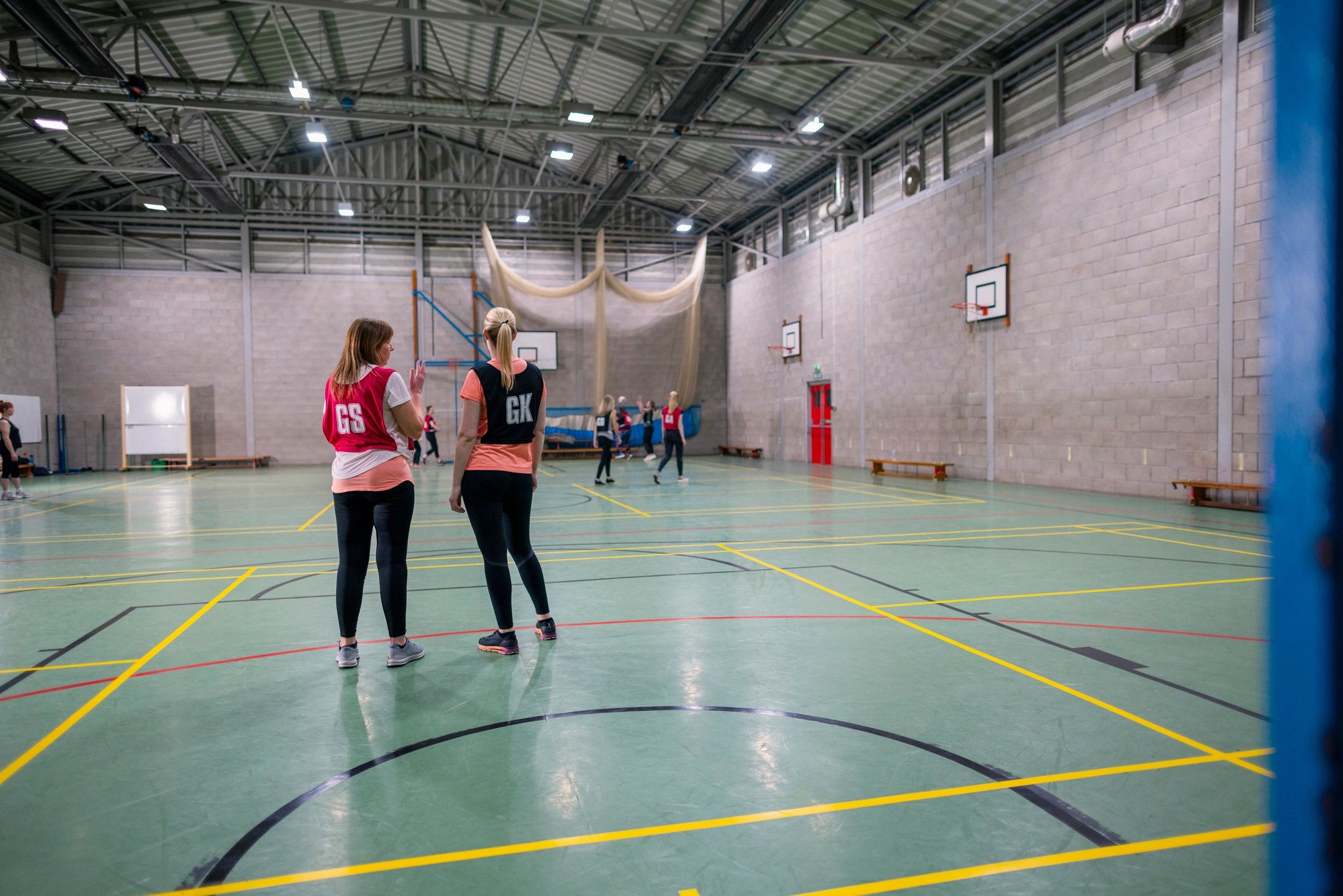 Students practising a court sport in an indoor hall
