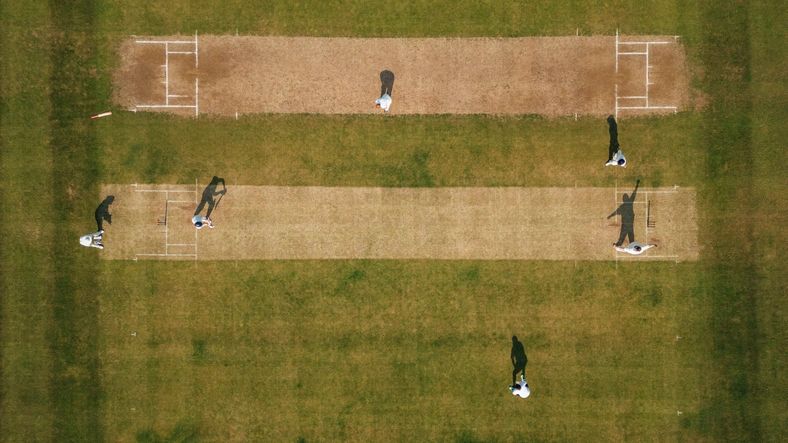 Students playing cricket on the sports ground