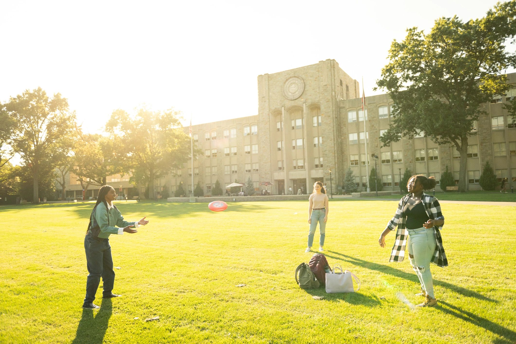 Students playing a sport on a campus lawn